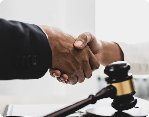Handshake with gavel symbolizing settlement